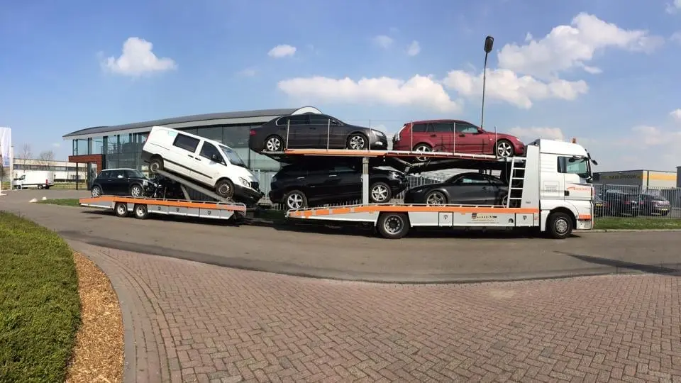 Voll beladener Autotransporter mit Pkw auf zwei Ladeebenen, am Straßenrand